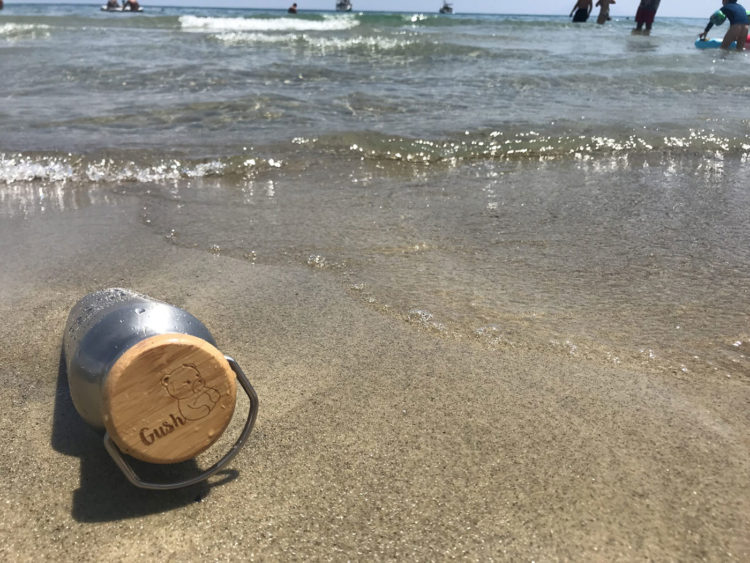 Стоманена термо бутилка за вода на брега на морето